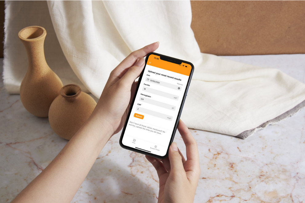 Woman holding a phone showing lab results in the Ferrivia app